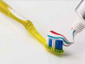 yellow toothbrush with toothpaste on it