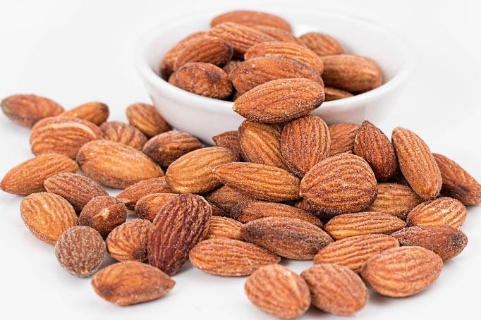 almonds in and around a white bowl