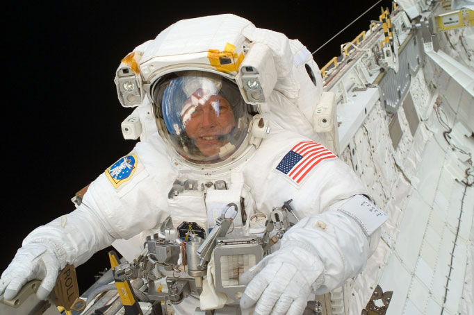 astronaut floating in space, space station the background