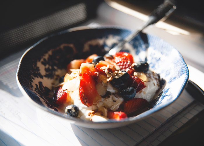 A bowl of yogurt topped with fresh berries for a summer snack