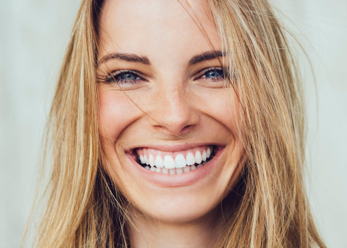 Blonde woman smiles because she is relaxed about her stress-free dental visit thanks to dental sedation