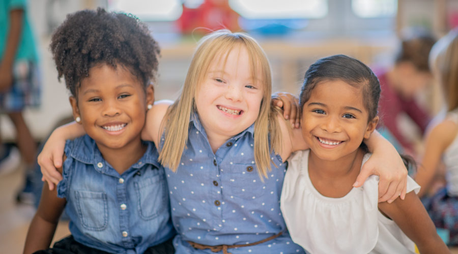 3 young girls smile before a dental procedure at Growing Smiles because they can relax with dental sedation