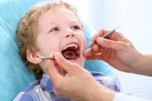 young boy in the dentist's chair getting dental sealants to help prevent cavities