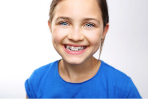 young girl smiles showing off her new braces