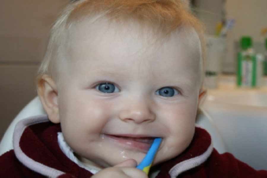 blue eyed baby boy brushing his teeth