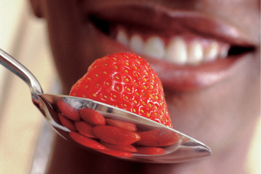 strawberry in a spoon about to be eaten