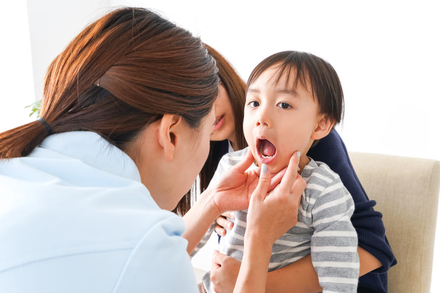 dentist looks at a young child's teeth 