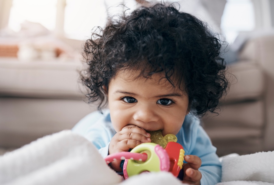 teething tips, teething baby chewing on teething toy